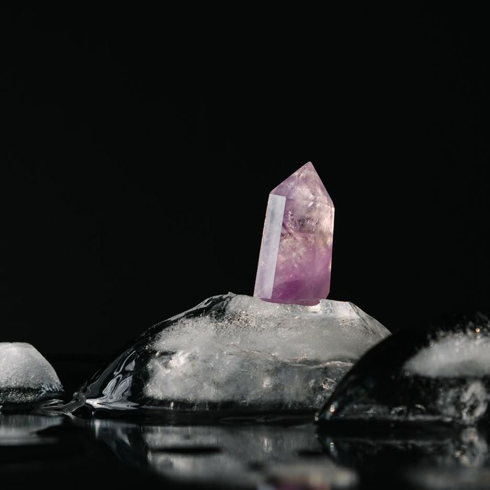 Amatista iluminada sobre hielo y fondo negro