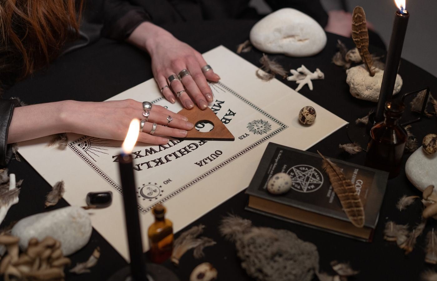 Mesa de trabajo con tabla de símbolos, tablilla de madera, velas y objetos rituales